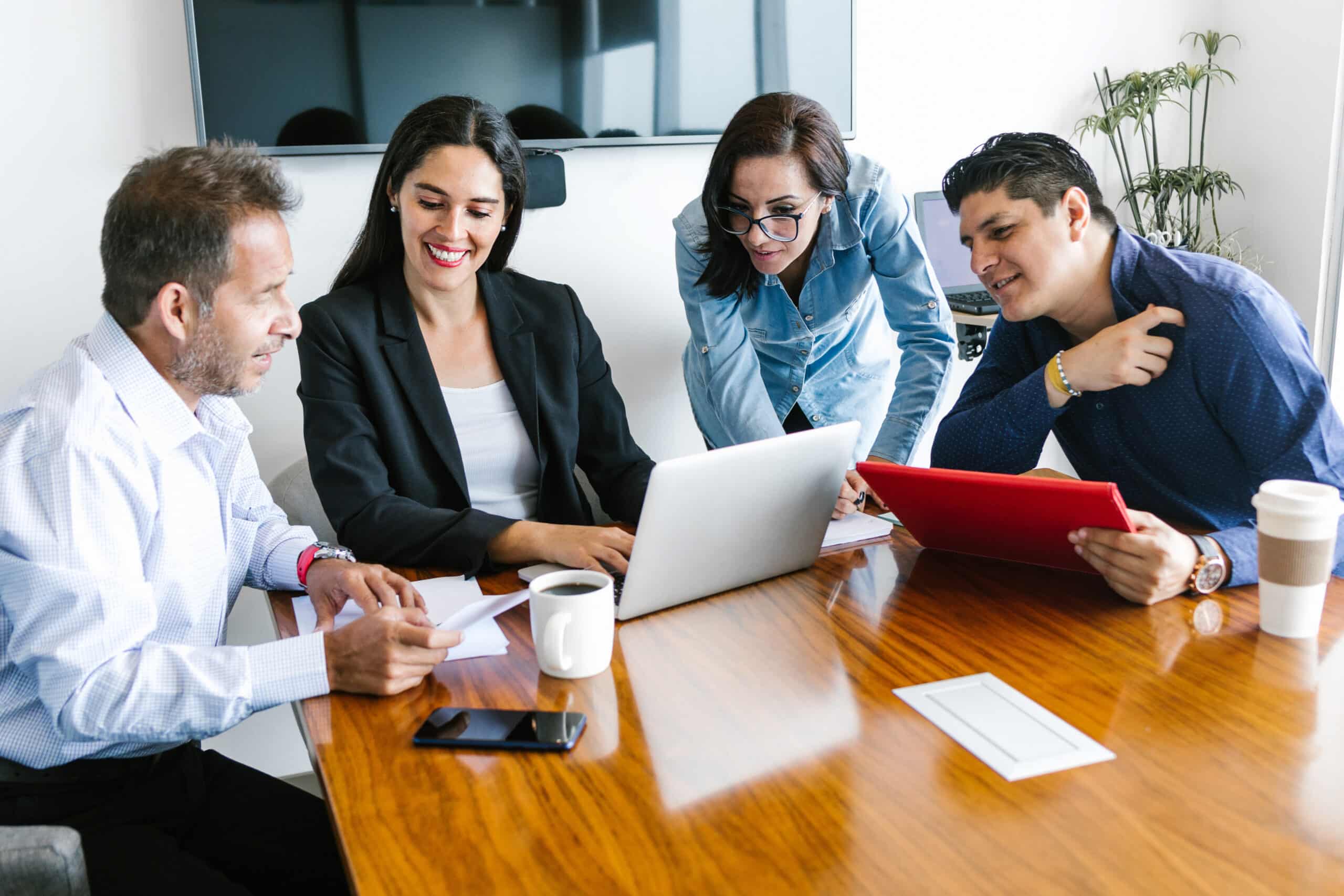 Mexican people in business meeting using computer in office in Latin America